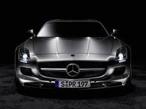 銀色梅賽德斯 SLS AMG 跑車的前視圖，帶有發光的頭燈。