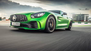 綠色Mercedes-AMG GT S在賽道上奔馳，帶有動態模糊效果。