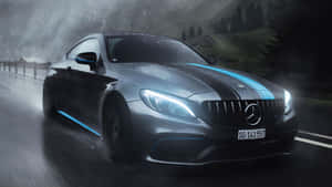 帶有藍色裝飾的銀色 Mercedes-AMG 在夜間潮濕的山路上疾馳。