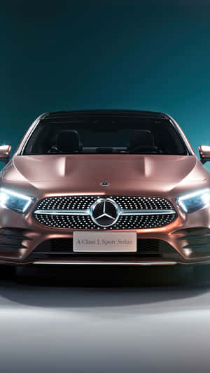 玫瑰金色平治A-Class L Sport Sedan在攝影棚燈光下的正面視圖。