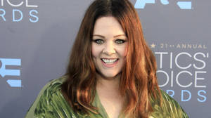 穿著綠色外套的女士在 Critics' Choice Awards 活動中微笑。
