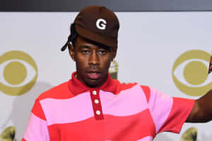 Tyler The Creator 在CBS活動中穿著紅粉條紋Polo衫和棕色帽子。