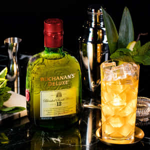 Buchanan's 威士忌酒瓶和薄荷裝飾的雞尾酒，在深色吧檯上。
