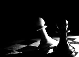 在戲劇性燈光下，棋盤上的兩個國際象棋兵卒。 — 黑白 壁紙