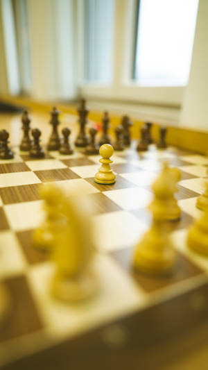 木製棋盤上聚焦的棋卒特寫，帶有模糊棋子和窗光。