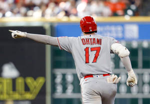 棒球手大谷翔平在夜間比賽中伸臂慶祝。 — 跑步 壁紙