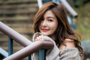 年輕女性喺戶外靠喺欄杆上微笑。 — 亞洲 壁紙