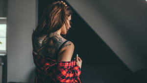 有紋身的女性在戲劇性燈光下室內掀起紅色格子襯衫 — 紋身 壁紙