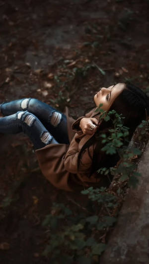 年輕女性在森林地面的落葉和藤蔓間休息