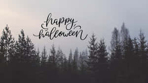 黎明時分霧氣籠罩的松樹林上方的 Happy Halloween 文字 — 萬聖節 壁紙