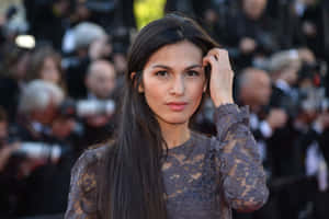 穿蕾絲裙的女士在紅地毯活動中與攝影師一起整理頭髮。