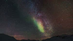 在繁星點點的夜空下，積雪的山峰上生動的極光
