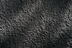 帶紋理的深灰色混凝土牆面特寫。