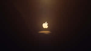 發光的Apple標誌置於深色背景中央，帶有金色光芒和陰影。