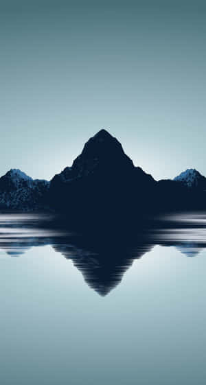 山峰完美地倒映在柔和的藍天下靜止的水面上。