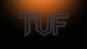 在深橙色漸變背景上，帶有分層金屬線條的風格化 TUF 標誌