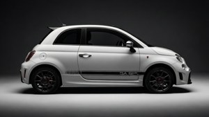 白色 Fiat 500 Abarth 跑車，配黑色飾條和紅色制動器，在攝影棚燈光下。