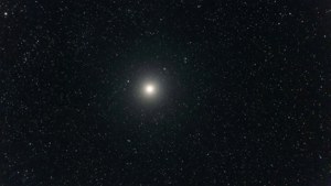 一個明亮的宇宙物體，帶有發光的光環，被深空中的星星包圍。
