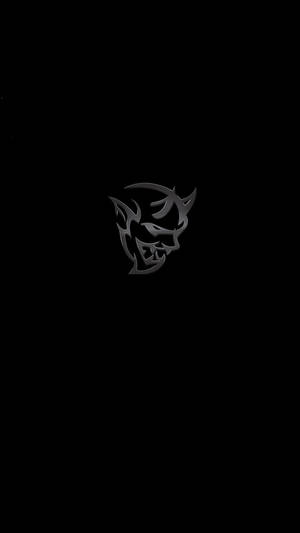一個風格化的惡魔面孔標誌，金屬灰色，黑色背景。