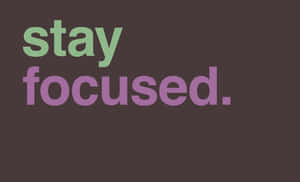 深棕色背景上以綠色和紫色顯示stay focused的勵志文字。 — 秋天 壁紙
