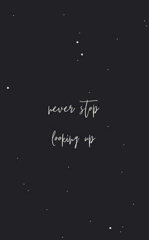深色背景，帶有白色星星和草書文字 never stop looking up — 星星 壁紙