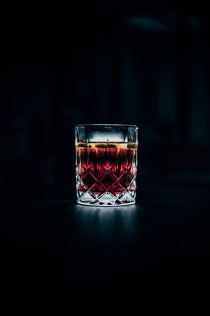 一個在黑暗中發光、帶冰塊的水晶威士忌杯