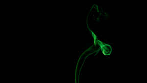 綠色煙霧在黑暗中以優雅的曲線旋轉。
