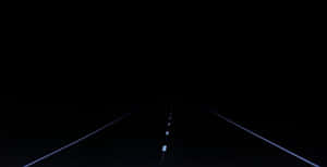 夜晚的黑暗道路，發光的白色車道標線延伸至遠方