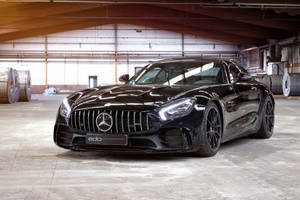 工業倉庫環境中的黑色 Mercedes-AMG GT R 跑車。