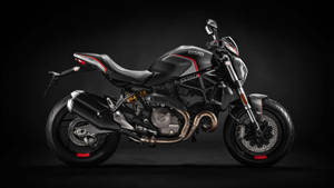 黑色Ducati電單車，帶有紅色點綴和鉻細節，背景深色。 — 機車 壁紙