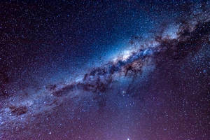 銀河系在黑暗的夜空中閃爍著藍色和紫色的星星。