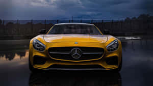黃色Mercedes-AMG GT在濕滑賽車場上，風暴天空下帶有倒影。