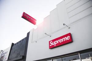 日落時分，白色建築上帶有紅色標誌的Supreme品牌商店。