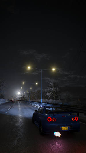 藍色跑車夜晚喺雪路上行駛，有街燈照明