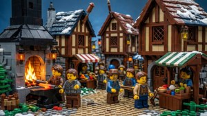 雪中的LEGO中世紀村莊，村民靠近發光的熔爐和市場攤位