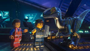 兩個LEGO人偶和一隻LEGO恐龍在夜晚的未來感控制室中。 — 反斗奇兵2 壁紙