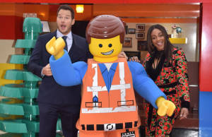 基斯柏特和一位女士在室內與巨型LEGO Emmet吉祥物合影。