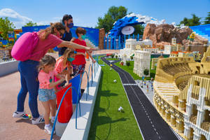 戴著口罩的家庭在主題公園觀看LEGO羅馬微型模型。