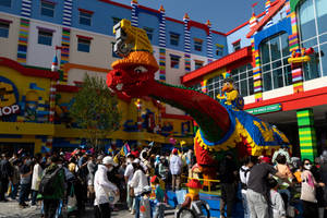 人們在LEGO主題公園聚集在一個巨大的LEGO恐龍雕塑周圍。