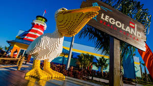 LEGOLAND Beach Retreat的大型LEGO鵜鶘雕像，配有燈塔和棕櫚樹。
