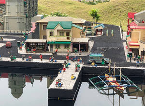 LEGO小鎮，建築物和人們在靠近海濱的地方，附近有一艘船。