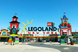 在晴朗藍天下，色彩繽紛的LEGO結構和大標誌的LEGOLAND New York入口。
