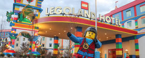 一個巨大的LEGO人仔站在LEGO Land Hotel前，帶有色彩繽紛的磚塊裝飾。