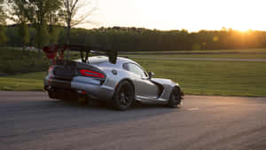 日落時分賽道上的銀色Dodge Viper GT3-R跑車與金色光芒。