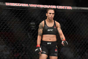 女性MMA拳手穿著UFC裝備，站在深圳大運中心體育館的籠內。