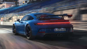 日落時分，藍色保時捷911 GT3 RS在賽道上疾馳。