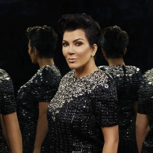 Kris Jenner 身穿黑色亮片連衣裙，身後有鏡面反射。