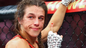 女性MMA拳手在八角籠內戴著UFC手套慶祝勝利。