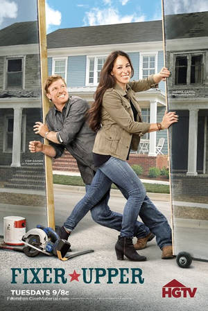 Chip 和 Joanna Gaines 在房子前拿著一面鏡子，附近有裝修工具。 — 2:3 壁紙