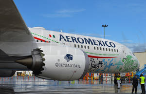 墨西哥航空飛機帶有奎茲特克設計，潮濕停機坪與地勤人員。